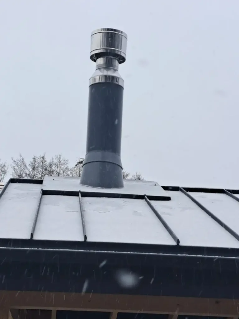 Kaminas ant stogo su stikline stogo dalimi.