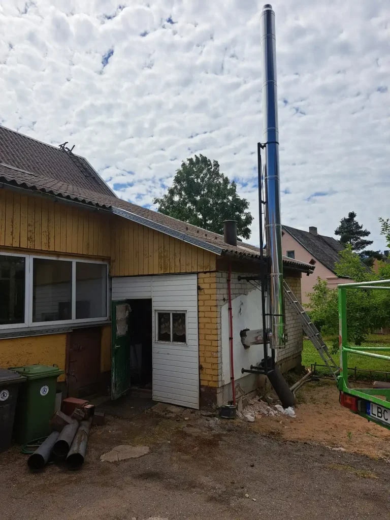 Namų fasadas su langu ir matomu stulpu šalia jo.